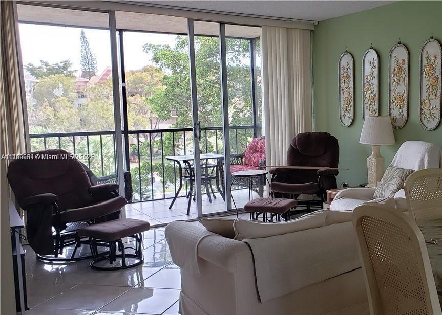 3821 Environ Boulevard, Unit 406 Lauderhill, FL 33319 - Photo 10 of 23 a living room with furniture fireplace and floor to ceiling windows