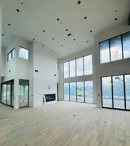 a view of an empty room with a fireplace and a window