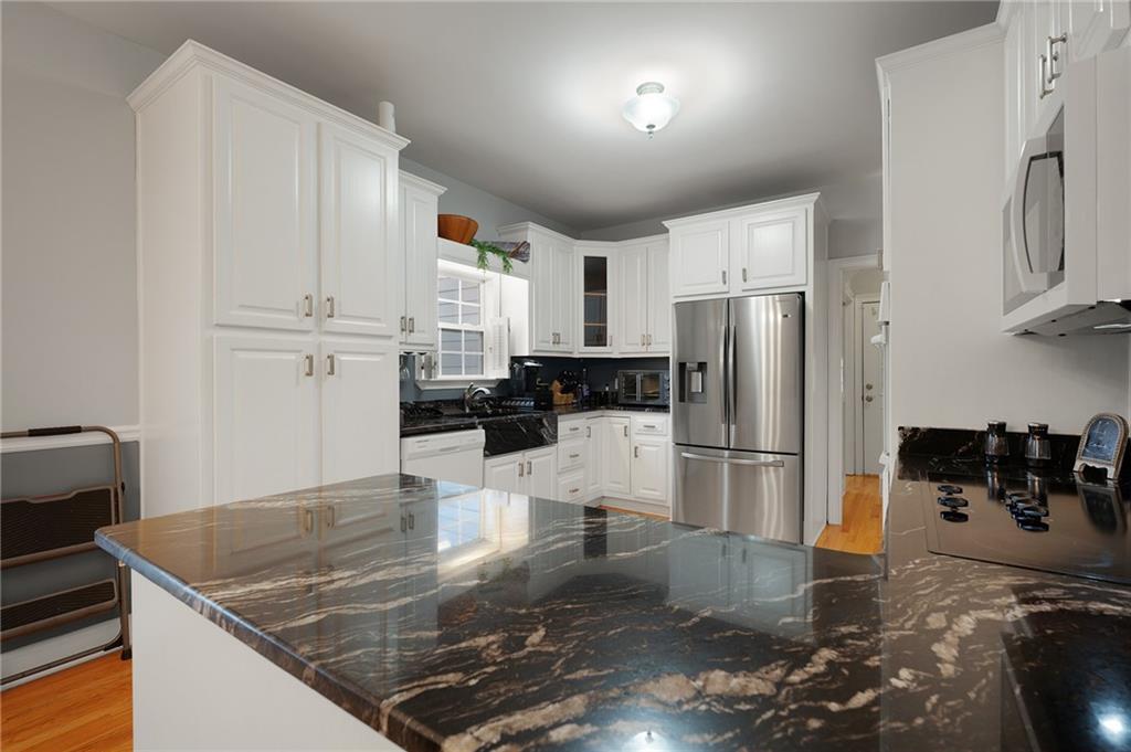 425 McDaniel Station Road Southwest Calhoun, GA 30701 - Photo 13 of 46 a kitchen with stainless steel appliances granite countertop a refrigerator a stove a sink a stove with white cabinets
