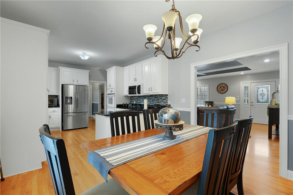 425 McDaniel Station Road Southwest Calhoun, GA 30701 - Photo 10 of 46 a view of a dining room with furniture a chandelier and wooden floor