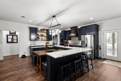 a kitchen with a dining table chairs sink and stove