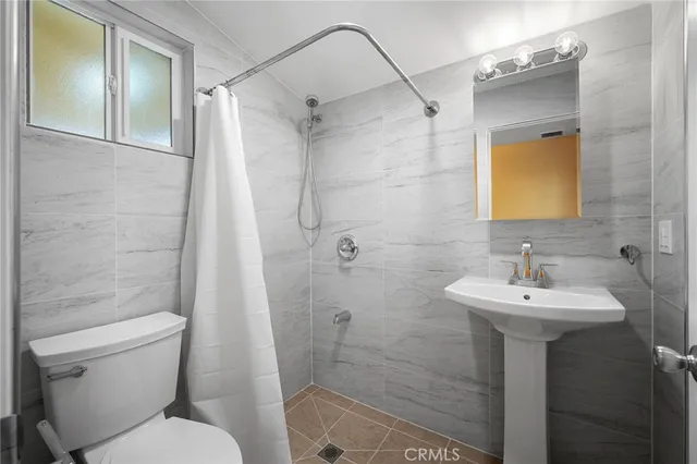 a bathroom with a sink mirror toilet and shower