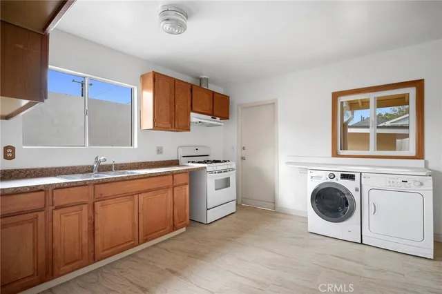 a view of a kitchen with a sink washer and dryer