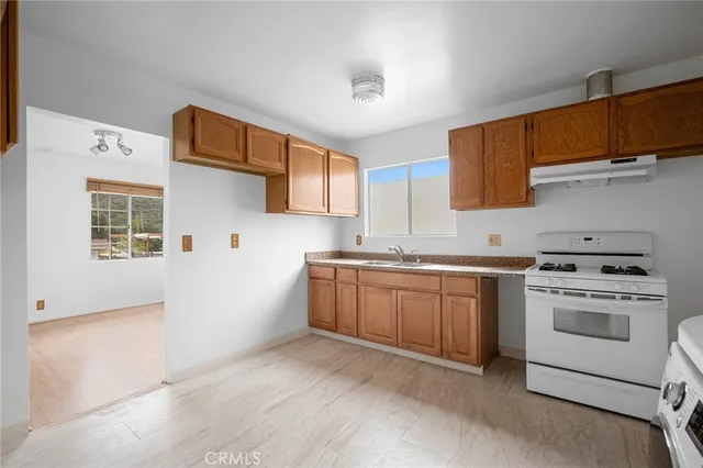 a kitchen with sink a stove and cabinets