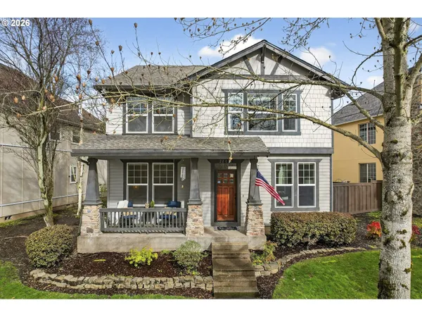 a view of a white house with large windows and a small yard