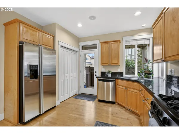 a kitchen with stainless steel appliances granite countertop sink stove top oven and cabinets