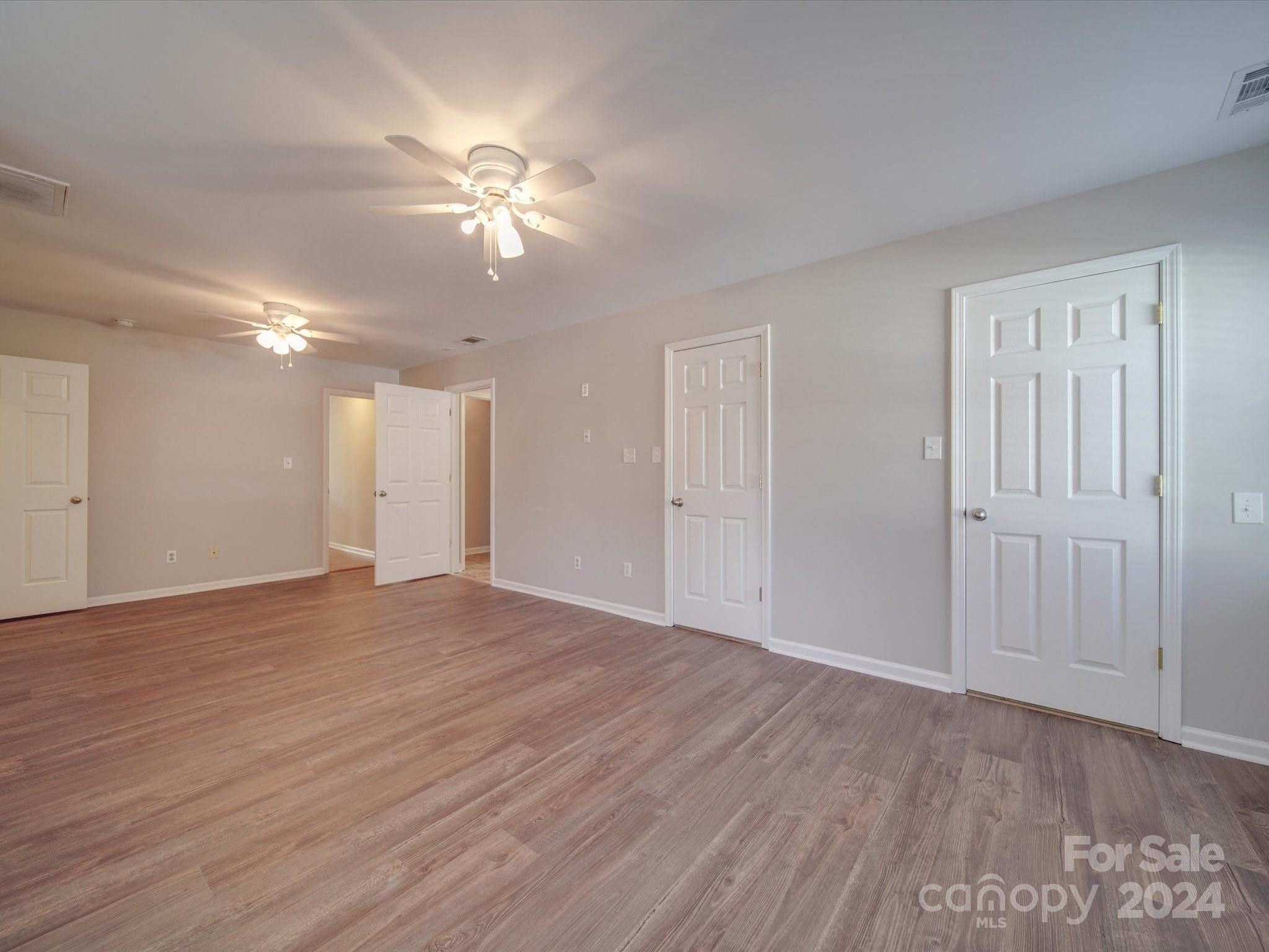 3806 Dusty Hollow Road Monroe, NC 28110 - Photo 14 of 21 a view of an empty room with wooden floor and a ceiling fan