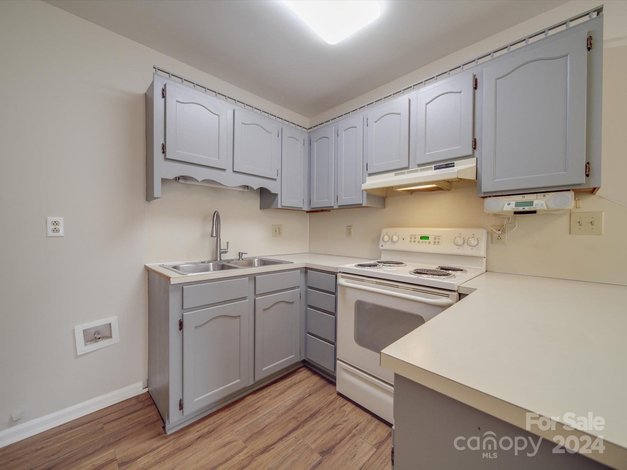 3806 Dusty Hollow Road Monroe, NC 28110 - Photo 17 of 21 a kitchen with cabinets stainless steel appliances a sink and wooden floor