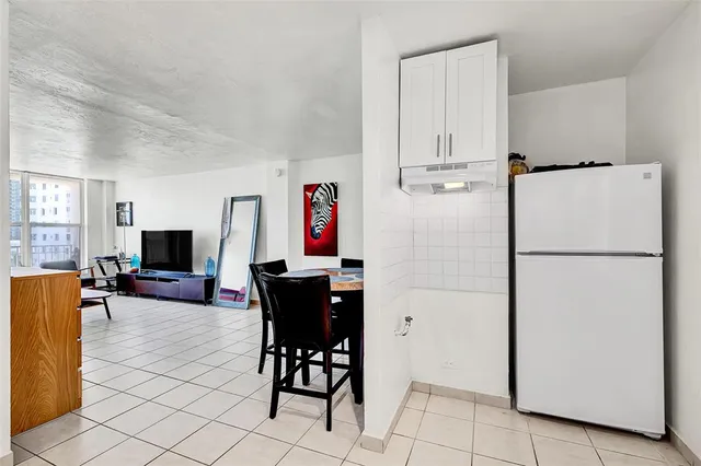 a view of kitchen with furniture electronic appliances and wooden floor