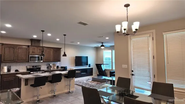 a view of kitchen with microwave stove top oven and cabinets