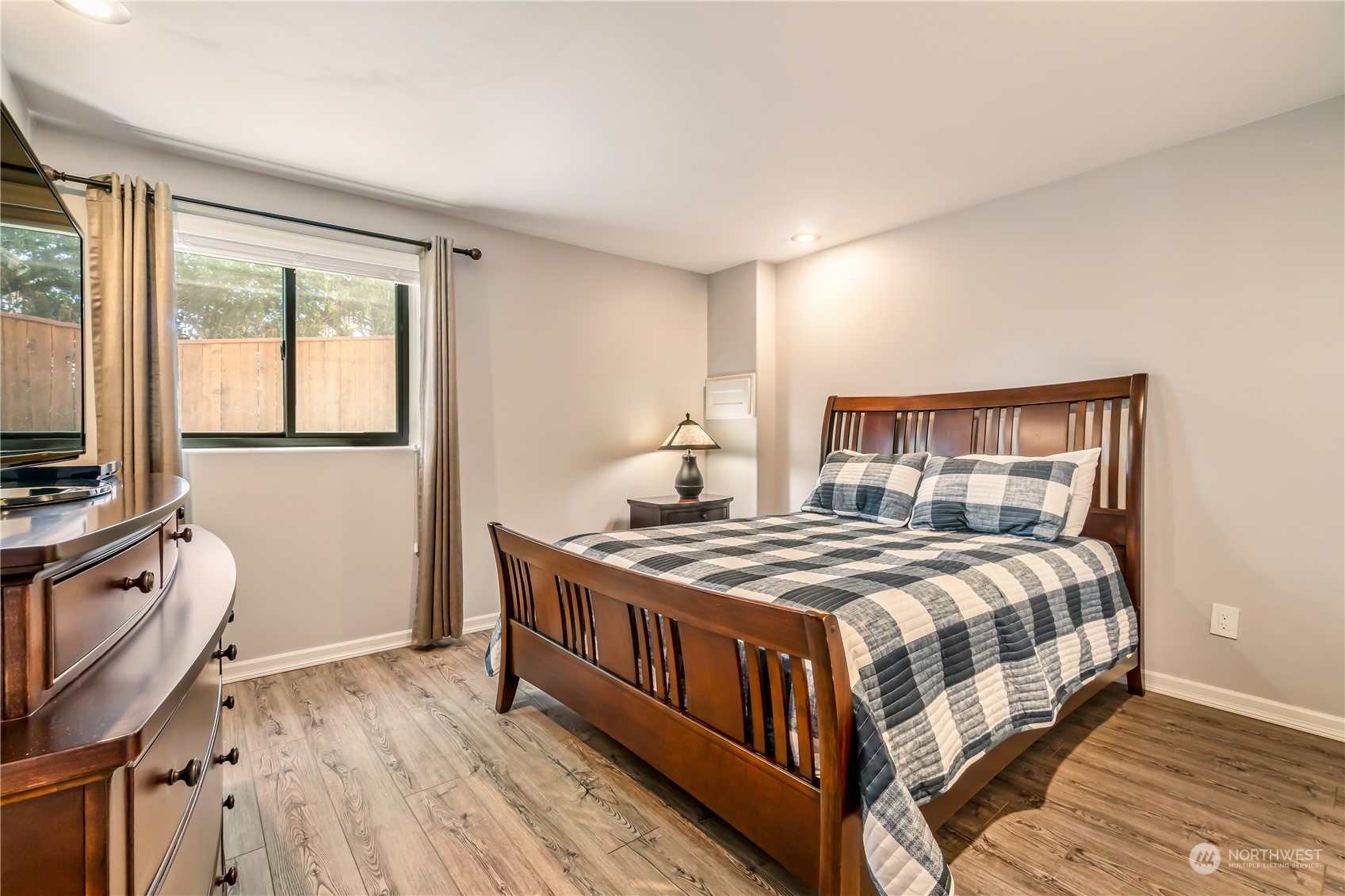 15333 West Lake Goodwin Road Stanwood, WA 98292 - Photo 34 of 39 a bedroom with a bed next to a window with wooden floor