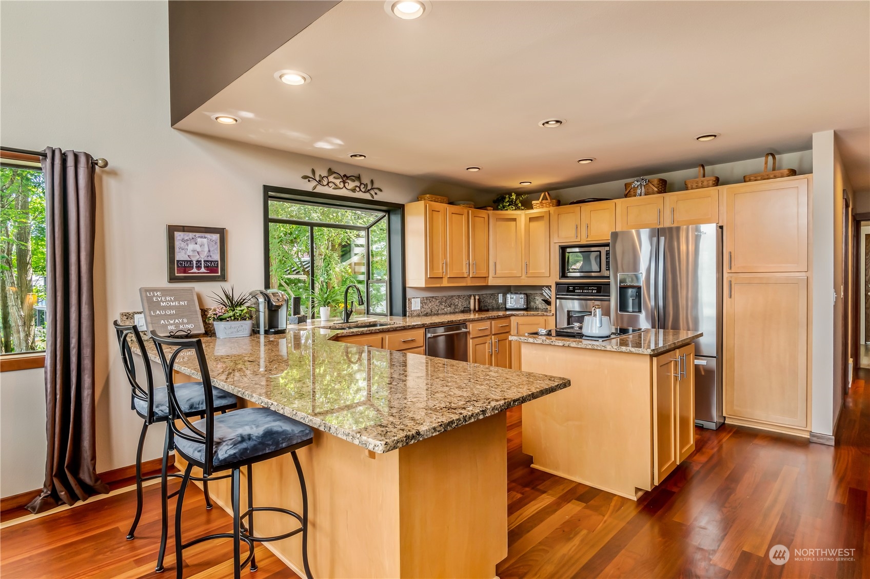 15333 West Lake Goodwin Road Stanwood, WA 98292 - Photo 10 of 39 a kitchen with stainless steel appliances granite countertop table chairs and a refrigerator