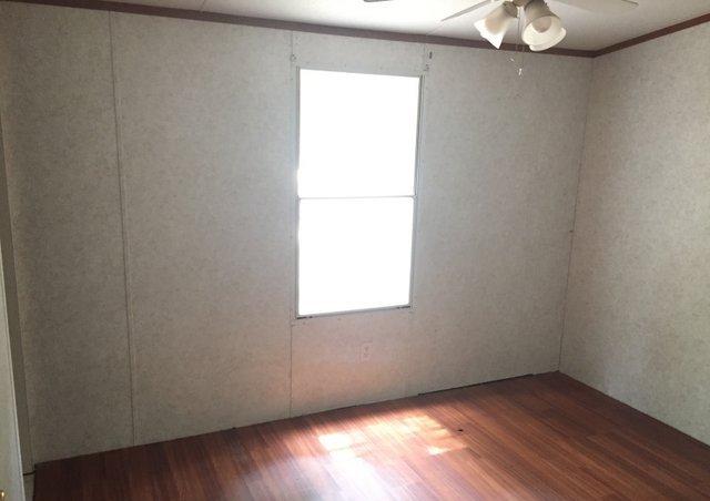 6146 Lake Ella Road Crestview, FL 32539 - Photo 8 of 12 an empty room with wooden floor and windows
