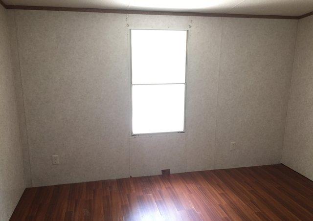 6146 Lake Ella Road Crestview, FL 32539 - Photo 9 of 12 an empty room with wooden floor and next to a window