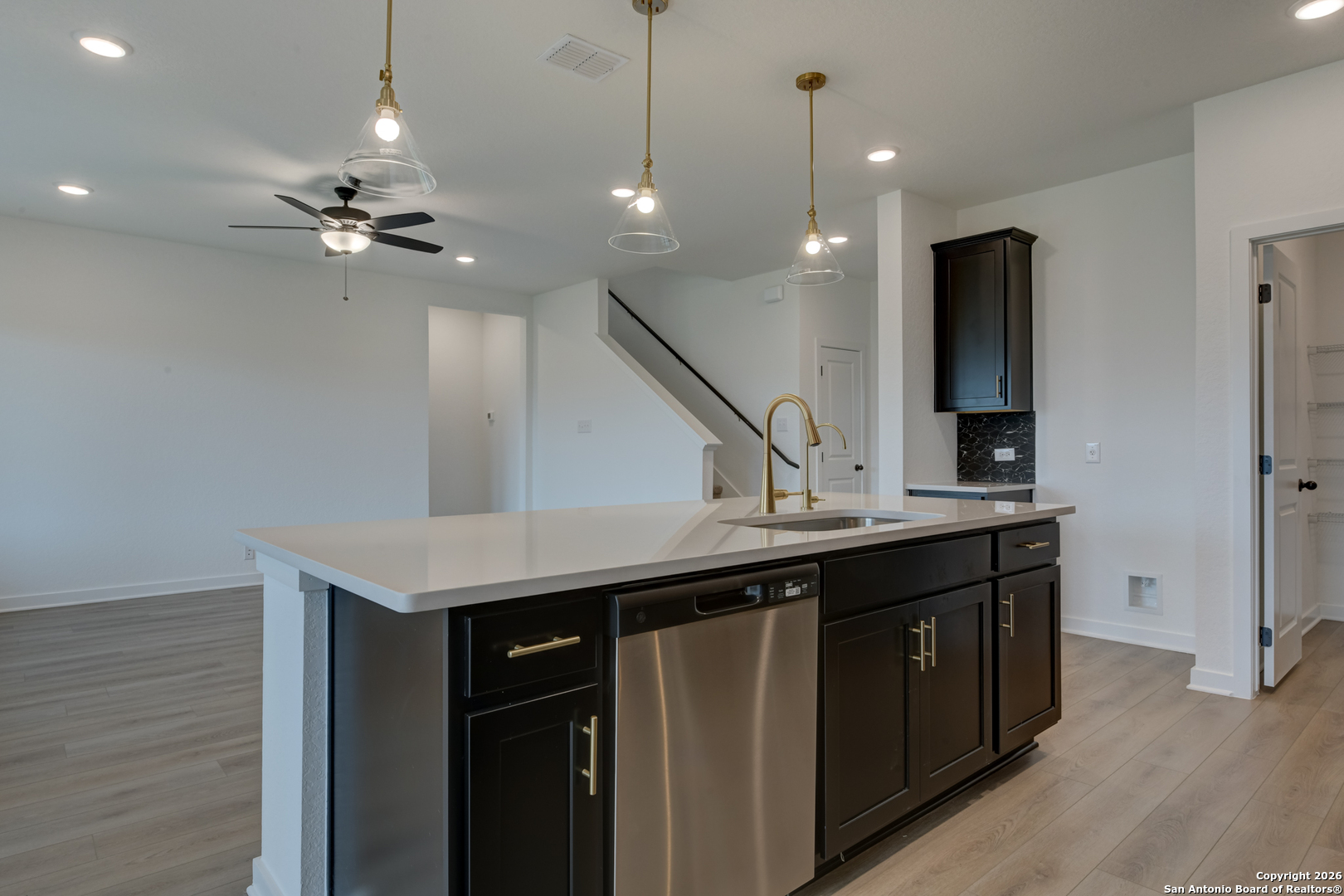12848 Red Apple Road Schertz, TX 78154 - Photo 11 of 37 a kitchen with a sink a refrigerator and a chandelier