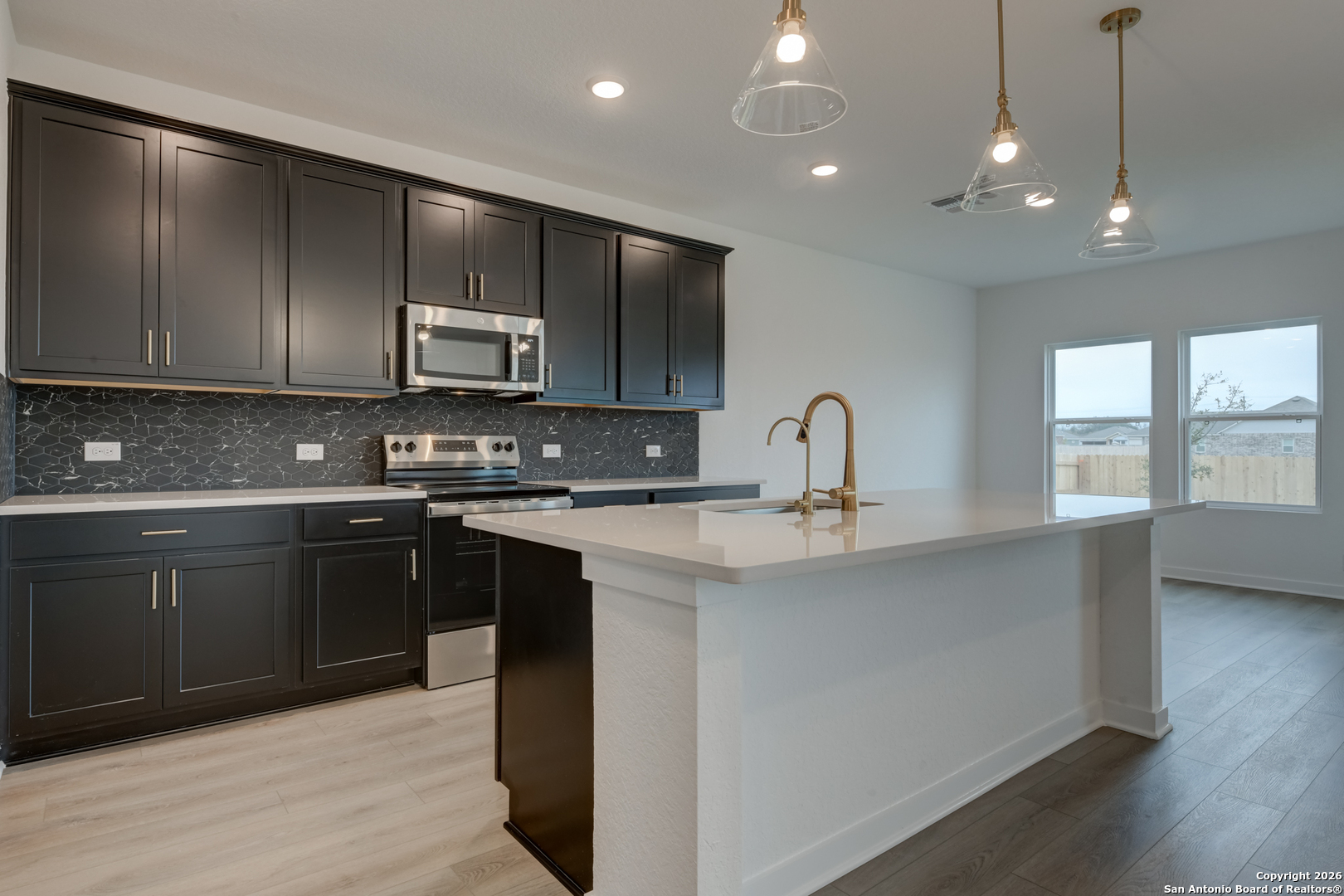 12848 Red Apple Road Schertz, TX 78154 - Photo 12 of 37 a kitchen with stainless steel appliances granite countertop a sink a stove and a refrigerator