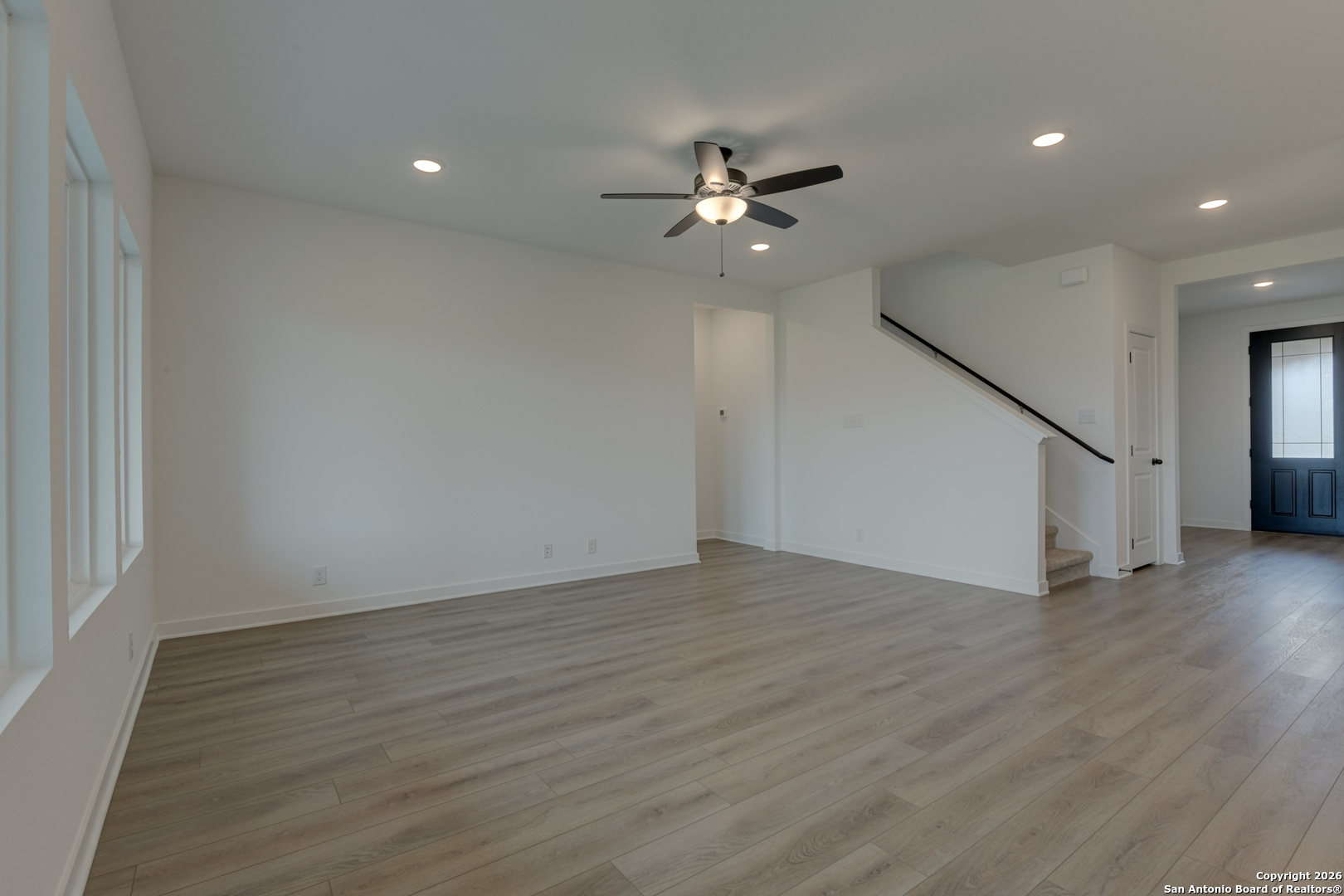 12848 Red Apple Road Schertz, TX 78154 - Photo 13 of 37 a view of an empty room with wooden floor and a ceiling fan