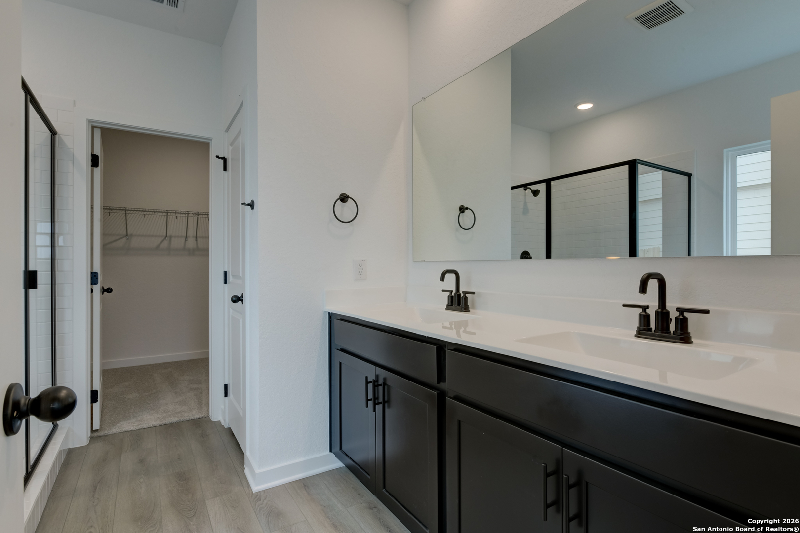 12848 Red Apple Road Schertz, TX 78154 - Photo 19 of 37 a bathroom with a double vanity sink a mirror and shower