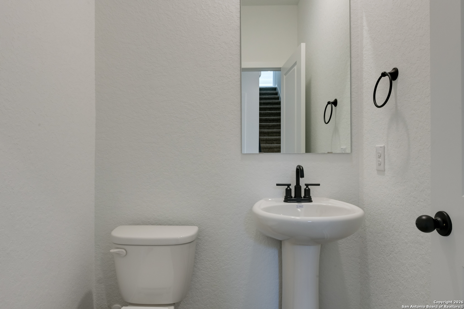 12848 Red Apple Road Schertz, TX 78154 - Photo 35 of 37 a bathroom with a sink a toilet and mirror