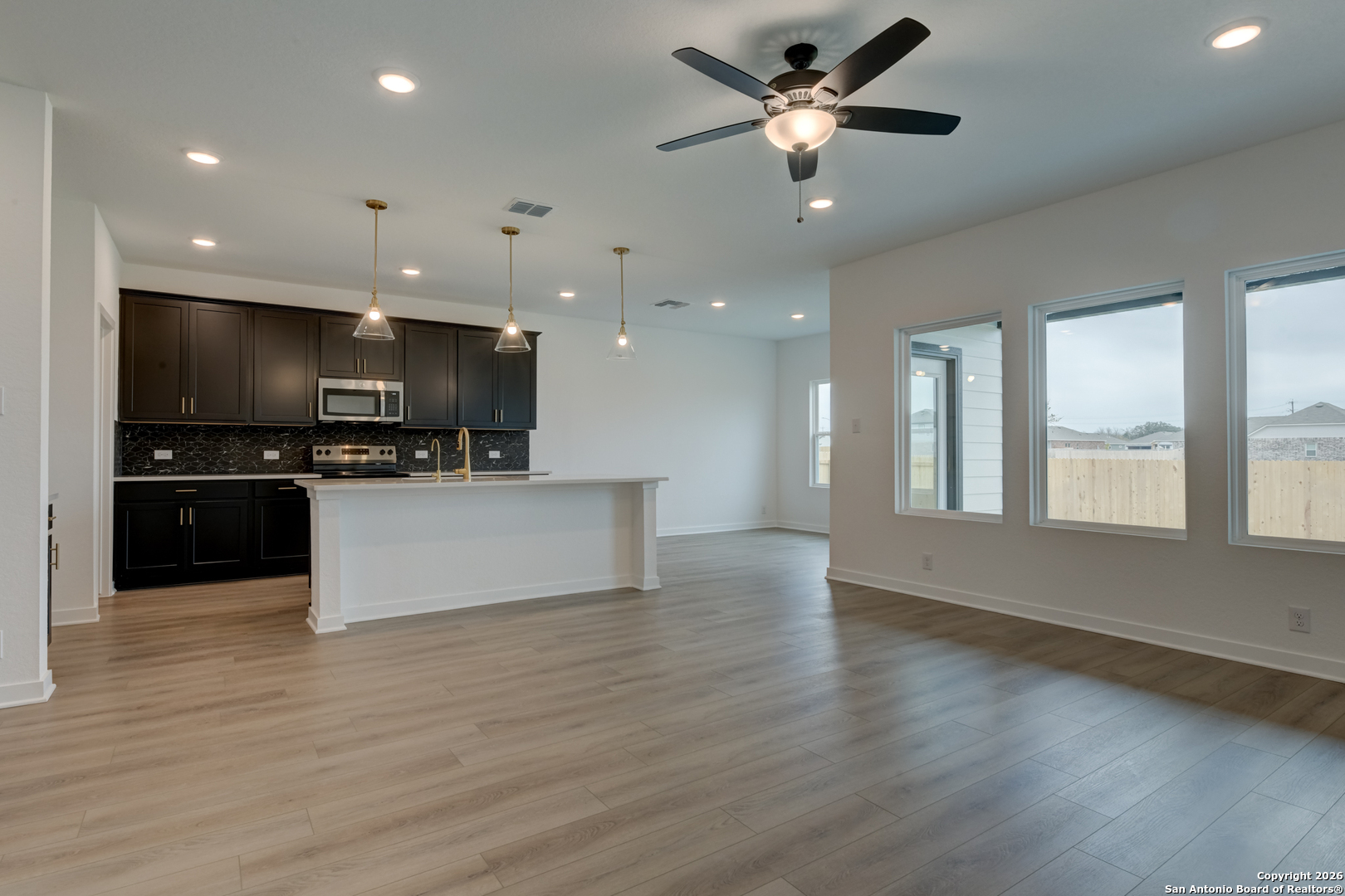 12848 Red Apple Road Schertz, TX 78154 - Photo 8 of 37 a view of kitchen with microwave a stove and a wooden floor