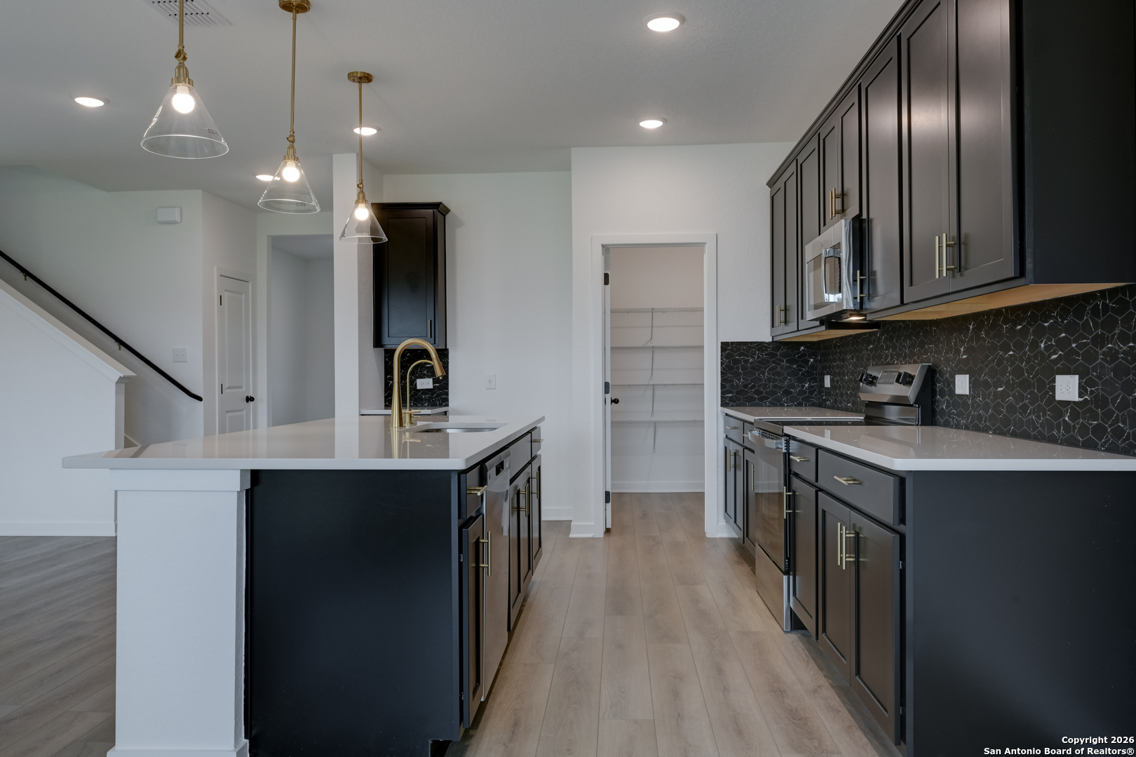 12848 Red Apple Road Schertz, TX 78154 - Photo 10 of 37 a kitchen with stainless steel appliances granite countertop a sink stove and refrigerator