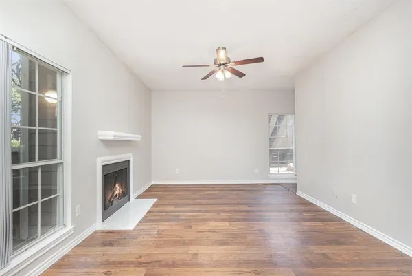 a view of empty room with wooden floor and fireplace