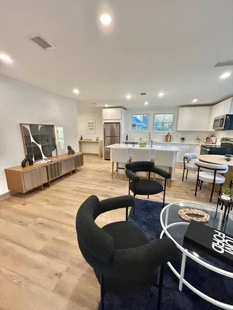 a living room with furniture and a dining table with kitchen view