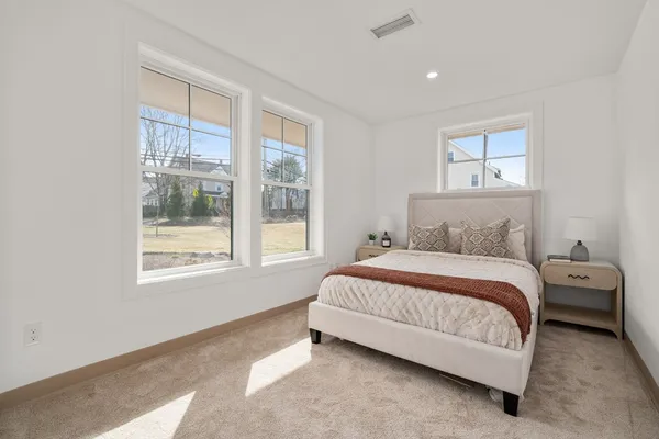 a spacious bedroom with a bed and wooden floor