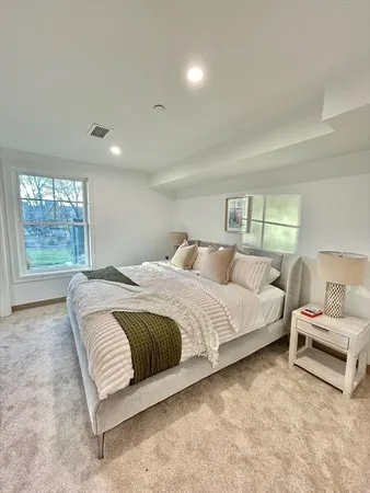 a spacious bedroom with a bed and a window