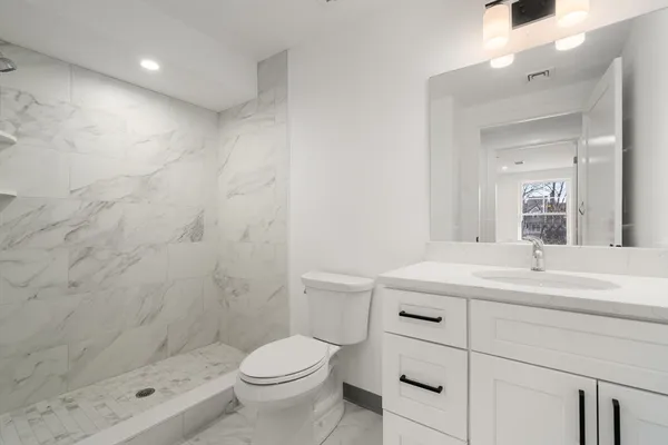 a bathroom with a sink a toilet and shower