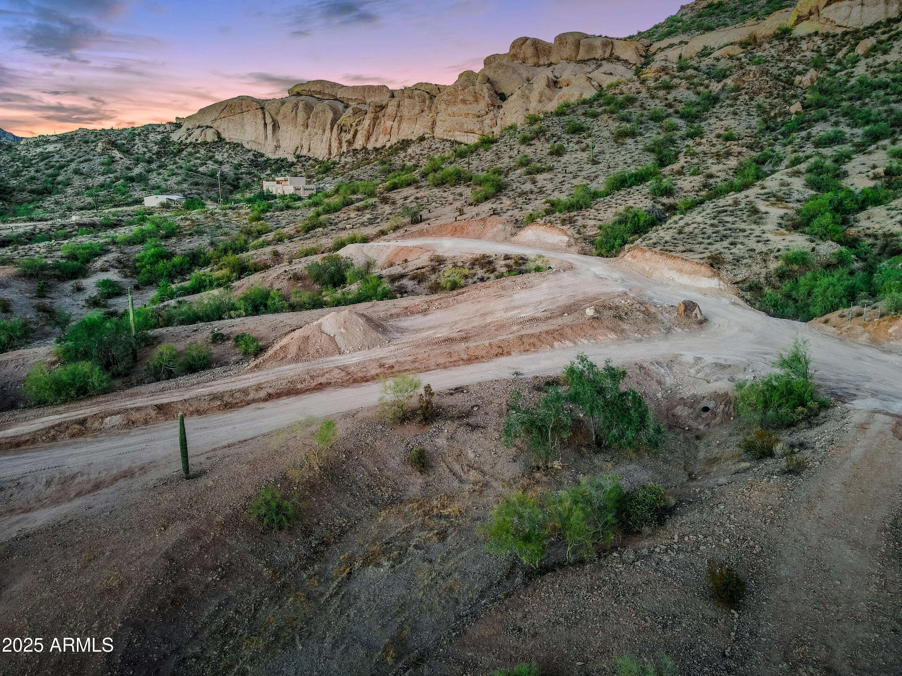 a view of a road with a yard and mountain view in back