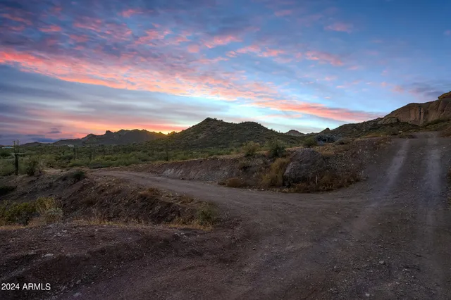 a view of a dry yard with mountains in the background