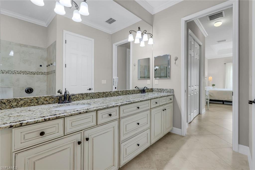 12832 Kinross Lane Naples, FL 34120 - Photo 14 of 45 Full bathroom featuring ornamental molding, double vanity, light tile patterned floors, a chandelier, and a walk in shower