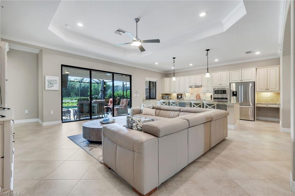 12832 Kinross Lane Naples, FL 34120 - Photo 5 of 45 Living area featuring a tray ceiling, ornamental molding, ceiling fan, recessed lighting, and light tile patterned floors