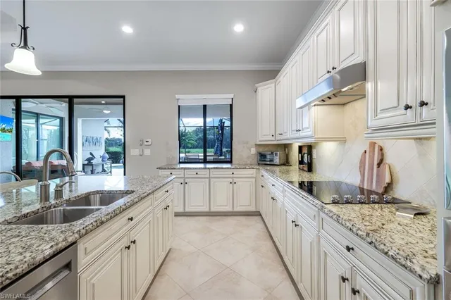 a large kitchen with granite countertop a sink and cabinets