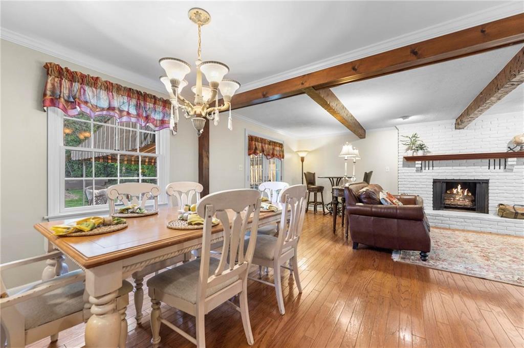 829 Ridgefield Avenue Pittsburgh, PA 15216 - Photo 16 of 50 a dining room with wooden floor a chandelier a wooden table and chairs