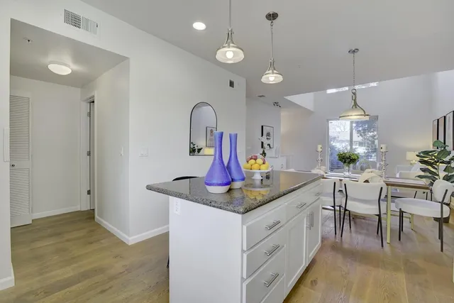 a kitchen with stainless steel appliances granite countertop a stove cabinets and wooden floor