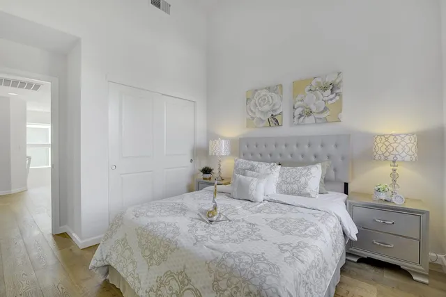 a bedroom with a bed and a lamp on dresser