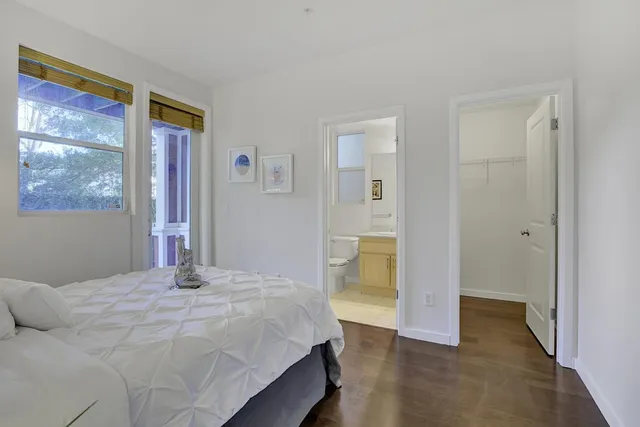 a bedroom with a bed and a painting on the wall