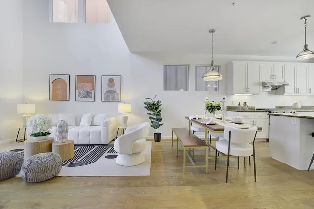 a living room with furniture kitchen view and a chandelier