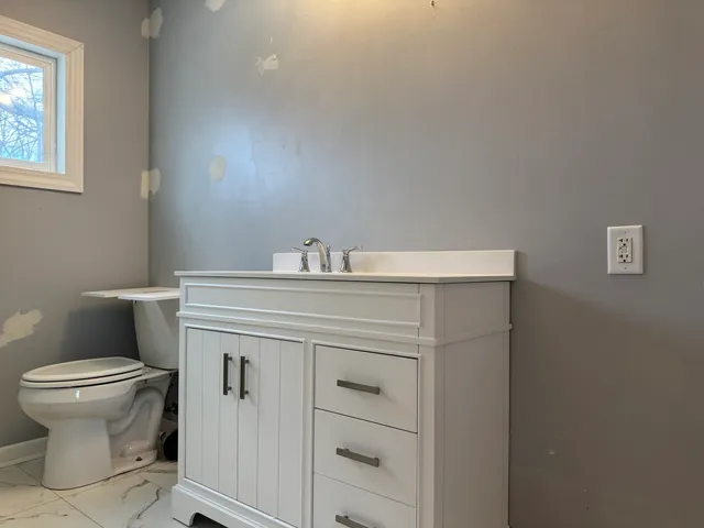 a bathroom with a sink toilet and a mirror