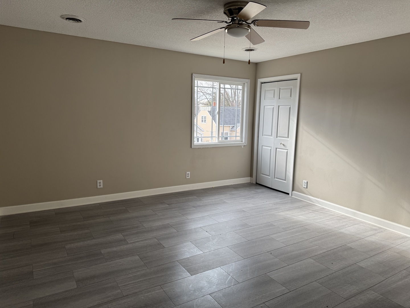 612 15th Avenue Sterling, IL 61081 - Photo 14 of 33 an empty room with wooden floor fan and windows