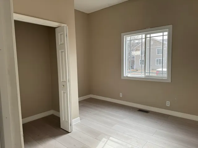 an empty room with windows and closet