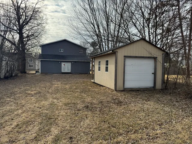 a view of house with a yard and large tree