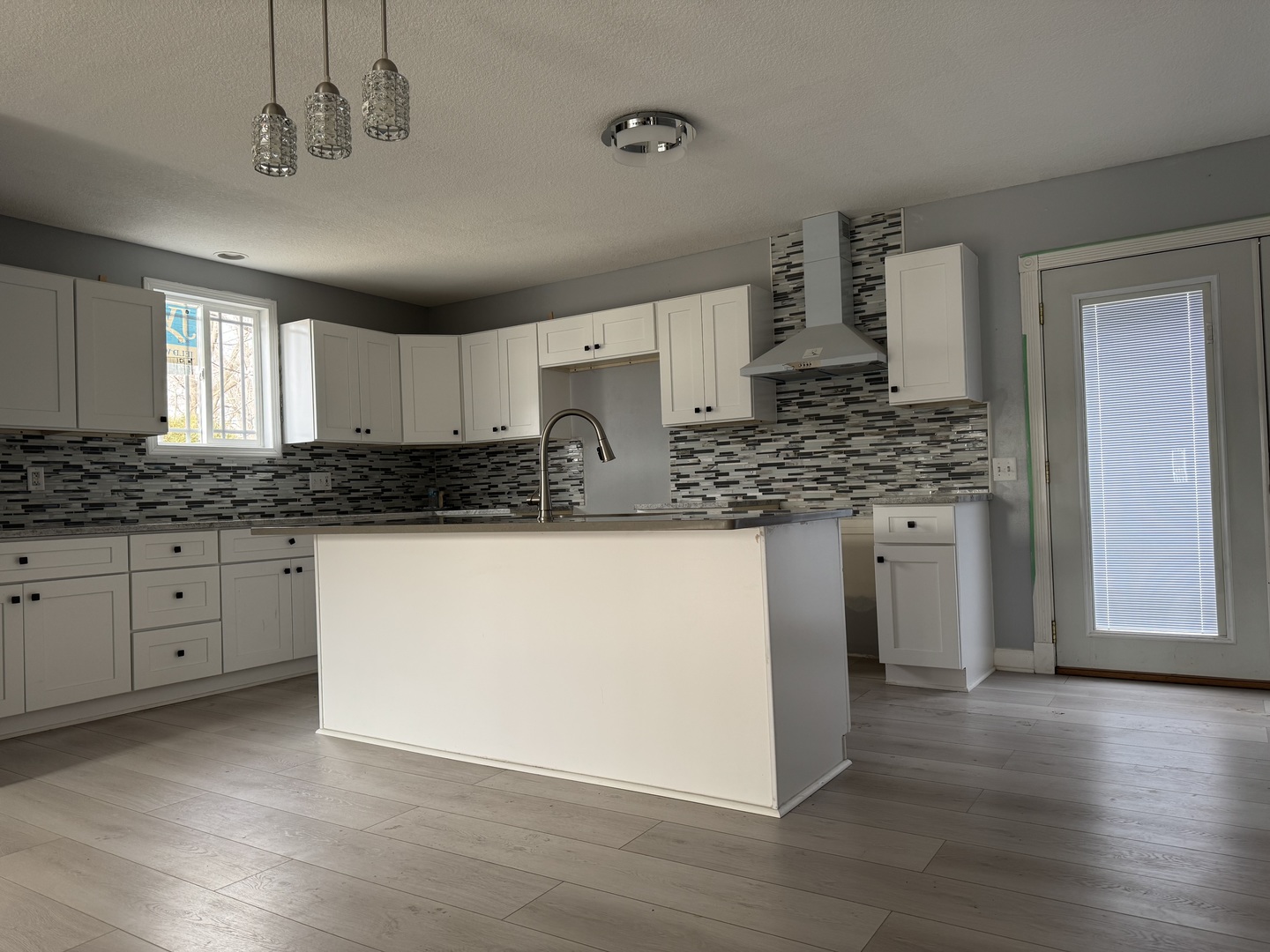 612 15th Avenue Sterling, IL 61081 - Photo 5 of 33 a kitchen with stainless steel appliances granite countertop a stove a sink and white cabinets with wooden floor