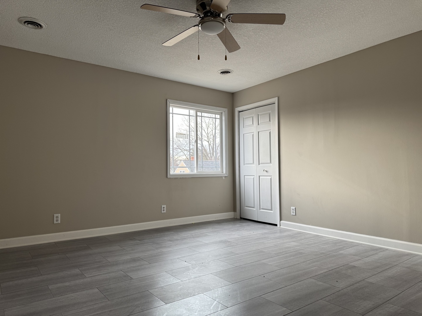 612 15th Avenue Sterling, IL 61081 - Photo 7 of 33 an empty room with a chandelier fan and windows