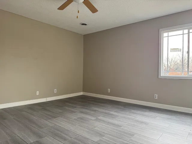 wooden floor in an empty room with a window