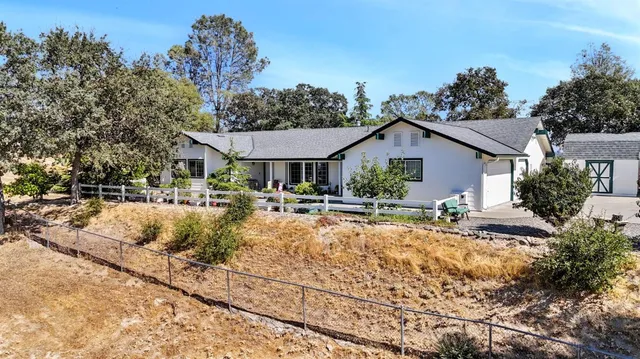 a front view of house with yard and trees around