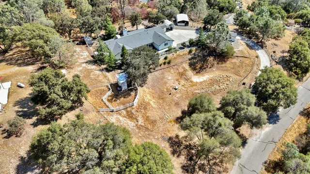 an aerial view of residential house with trees all around