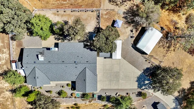 an aerial view of a house with a yard and mountain view in back